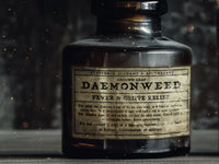A fictional product in an old dusty brown glass bottle, the label is written using the adderbite font, it has a very dark, fantasy aesthetic