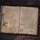 An open book filled with indecipherable handwriting, used to promote the free Garbled Hand font 