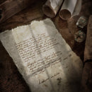 Promotional image used to advertise the free dungeons and dragons font called garbled hand, an old mysterious note sits on a desk with dice and scrolls