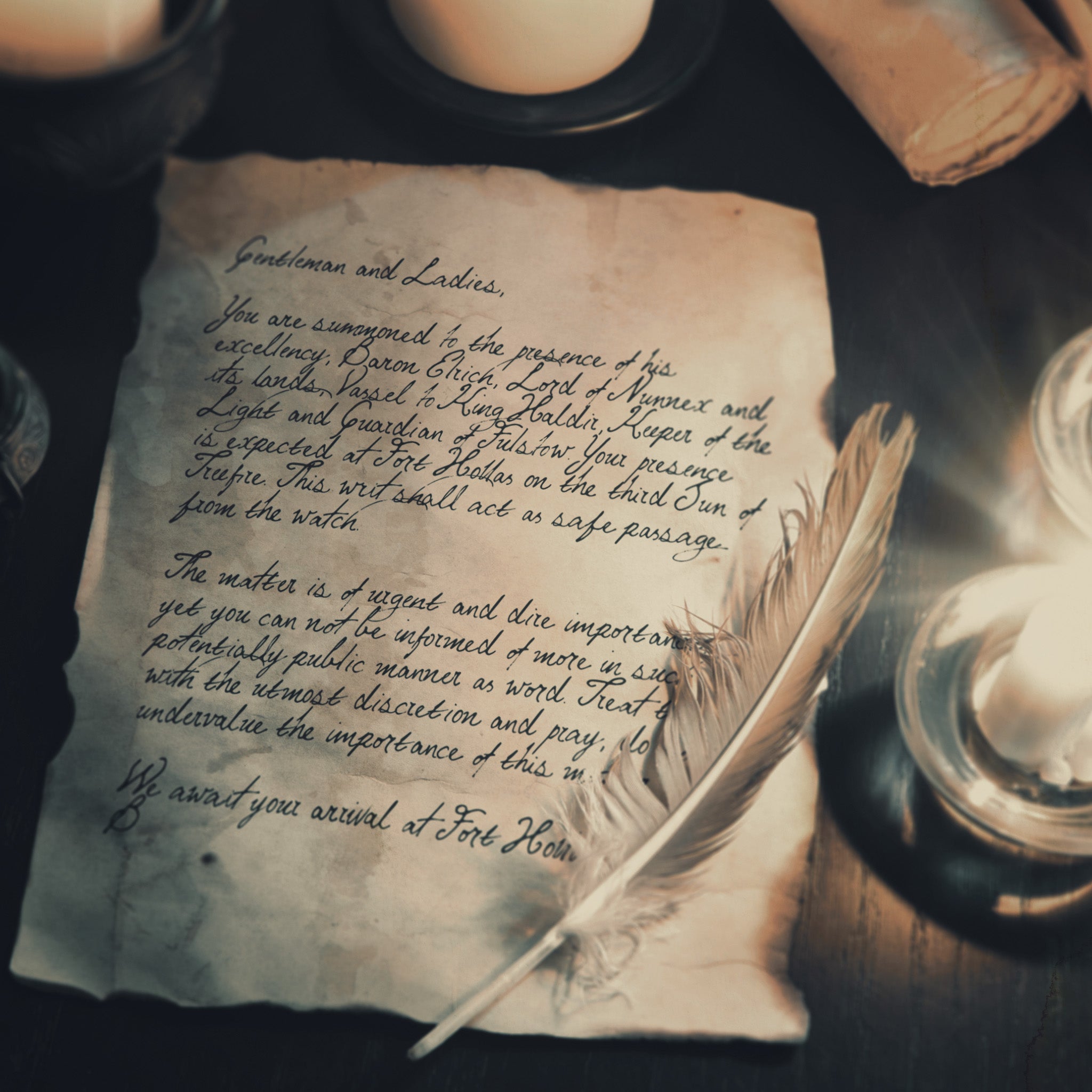 photo of an old letter written on parchment with a white feather resting on the paper 