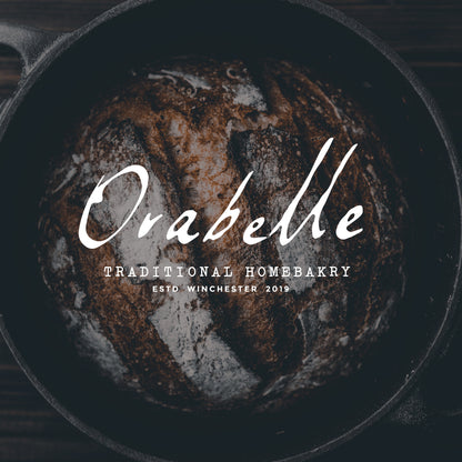 Orabelle bakery name set in Bliaunt script overlaid on a dark image of backed bread