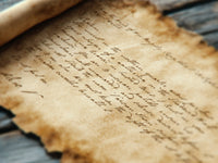 A ttrpg prop of an old, handwritten letter on a wooden surface