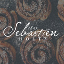 A faded image of spiral pasteries from above, the word Sebastien Holts is written on white on top.