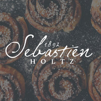 A faded image of spiral pasteries from above, the word Sebastien Holts is written on white on top.